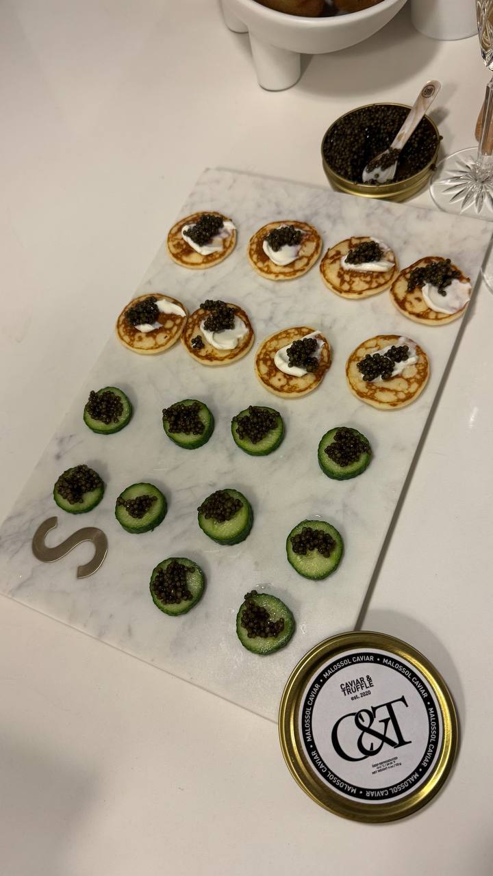Blini and cucumber canapes topped with Kaluga Hybrid caviar