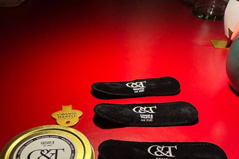 Caviar and Truffle tin and branded spoon pouches set up at a brand activation