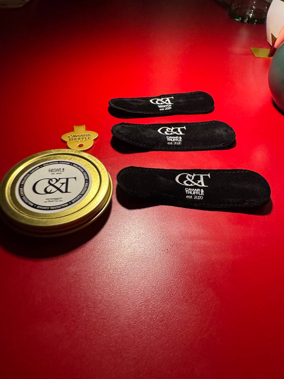 Caviar and Truffle tin and branded spoon pouches set up at a brand activation